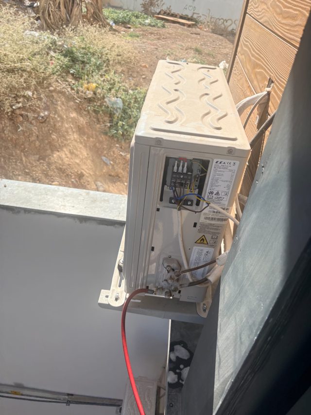 Dış ünitenin klemens kapağı açık, elektrik ve boru bağlantıları görünür