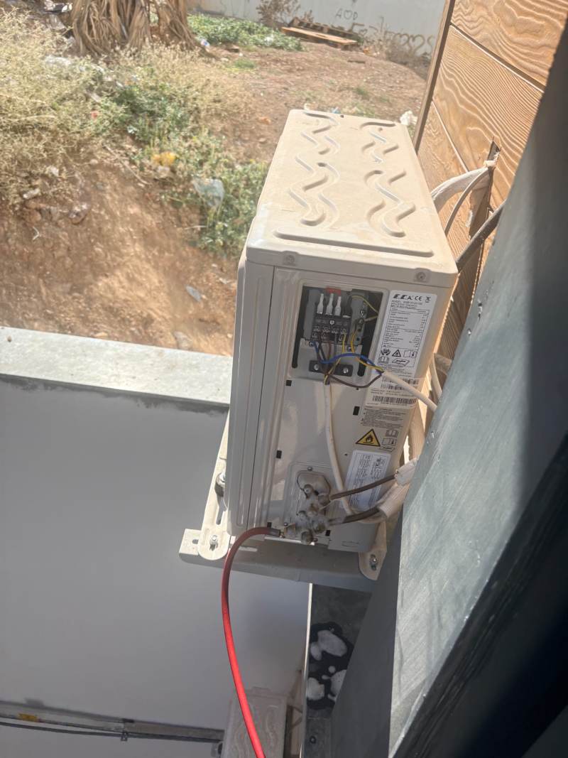 Dış ünitenin klemens kapağı açık, elektrik ve boru bağlantıları görünür