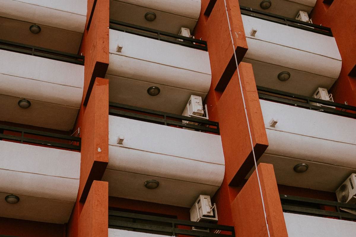 Ege'de bir apartmanın balkon katlarında sıralanmış klima dış üniteleri