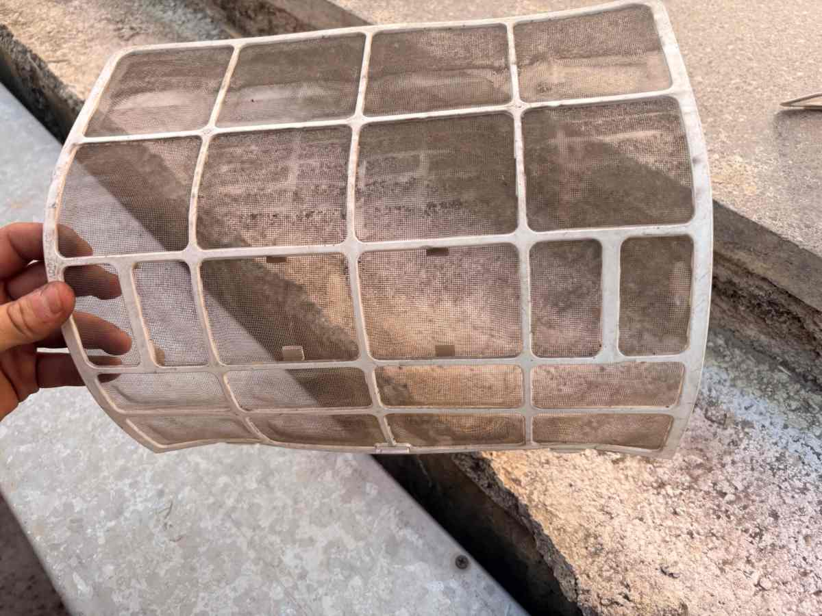 Sökülen iç ünite filtresi elde tutuluyor; gözenekler tozla kapanmış