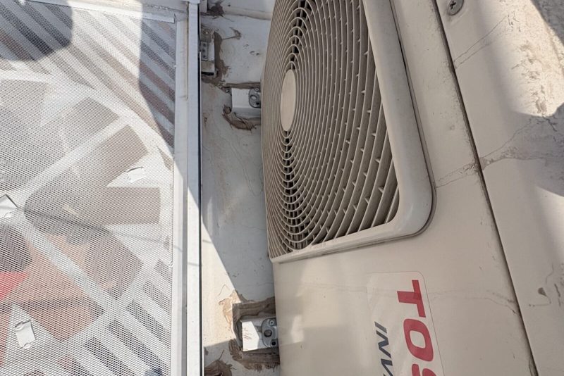 Toshiba inverter dış ünitesi yakın plan; koruma ızgarası ve gövde yan yüzeyi