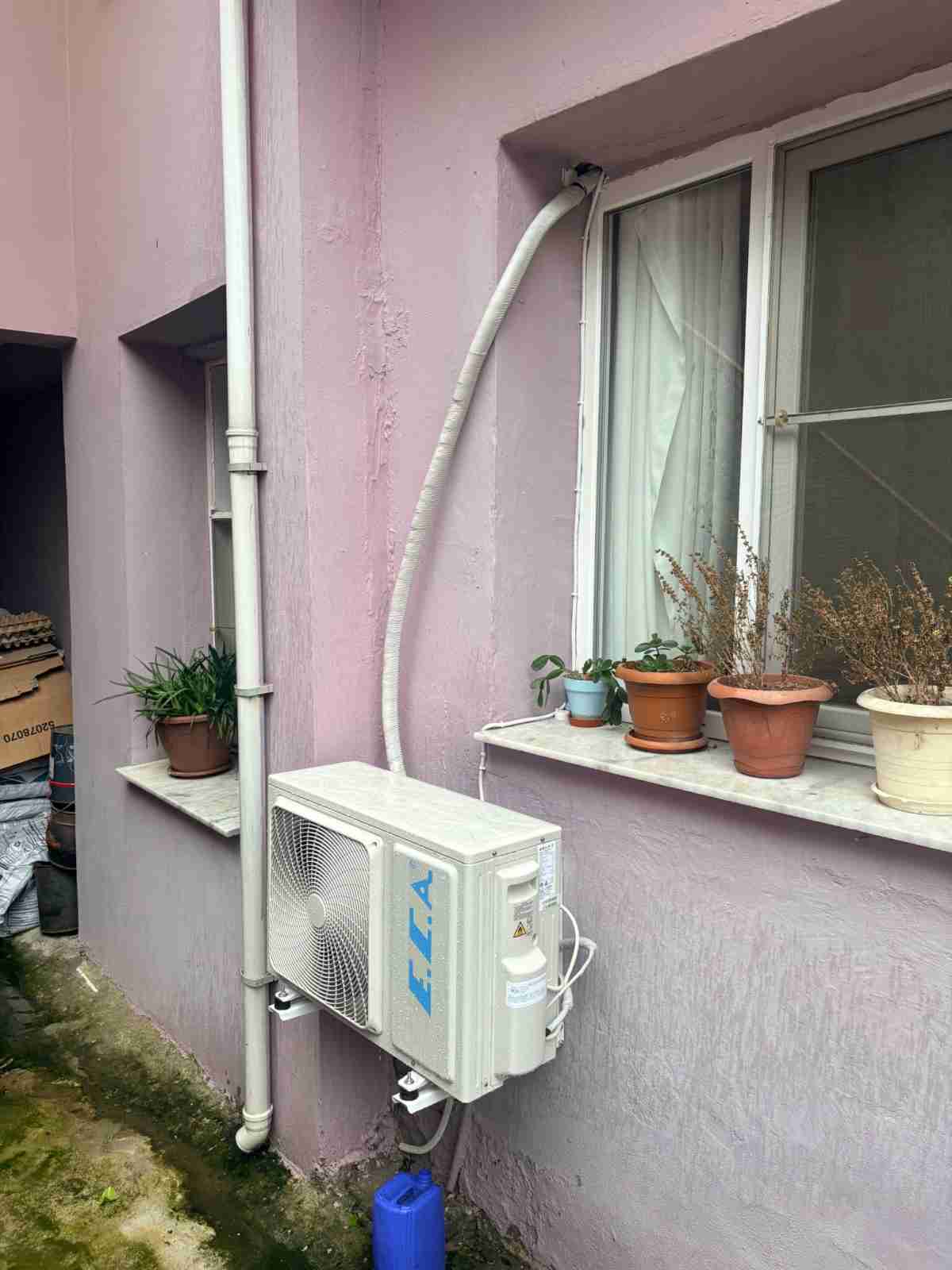 Müstakil evin dış cephesinde, pencere altına konsolla asılmış dış ünite